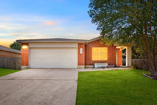 a view of a house with a big yard and large tree
