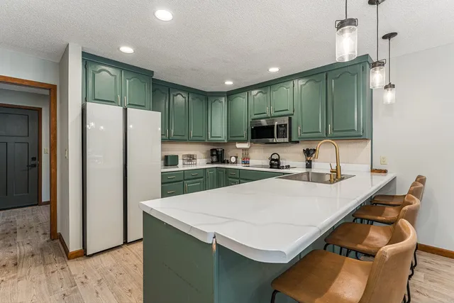 a kitchen with stainless steel appliances granite countertop a refrigerator and a sink