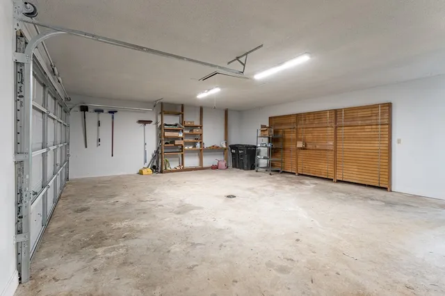a bedroom with a bed a chandelier and a chair
