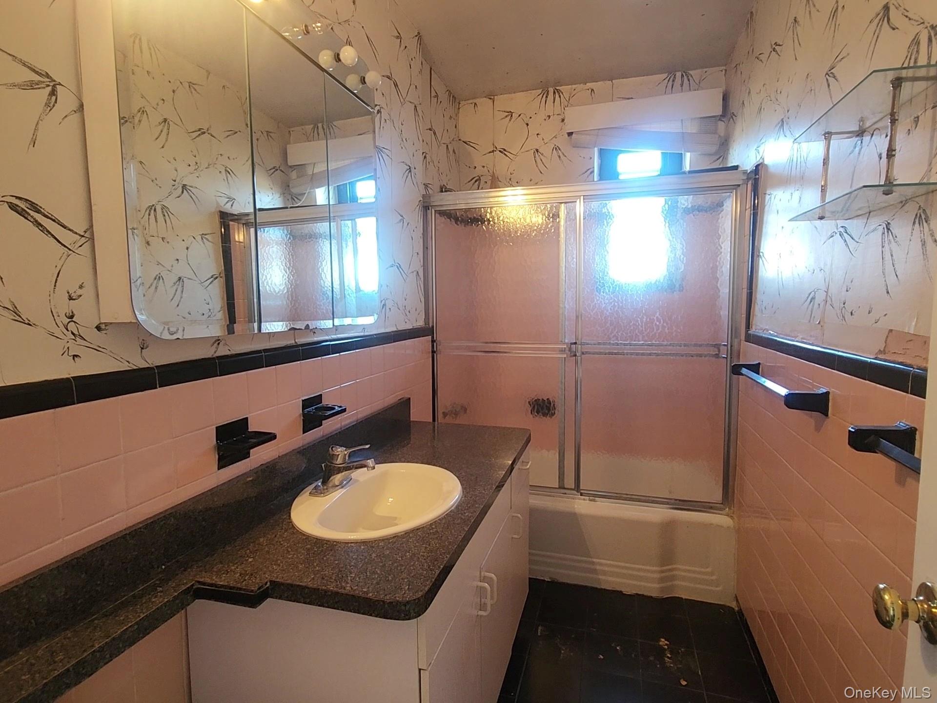 90-09 Northern Boulevard, Unit 605 Queens, NY 11372 - Photo 12 of 16 a bathroom with a sink a toilet a mirror and shower