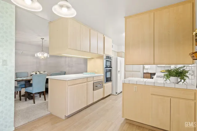 a kitchen with a sink a stove cabinets and wooden floor