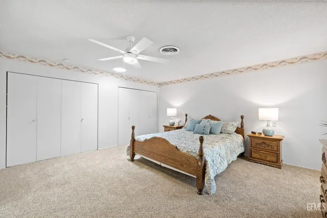 a spacious bedroom with a bed and a ceiling fan