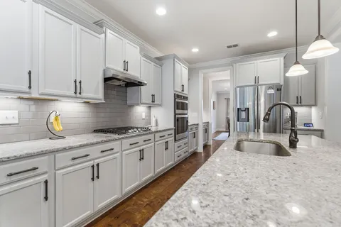 a large kitchen with stainless steel appliances granite countertop a lot of counter space