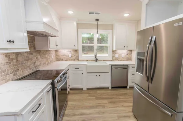 a kitchen with a sink stove and refrigerator