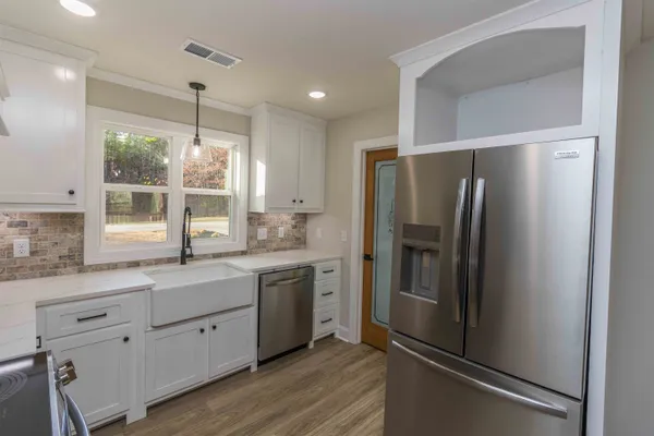 a kitchen with a refrigerator sink and cabinets
