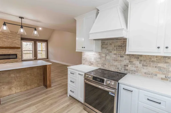 a kitchen with a stove and a white cabinets