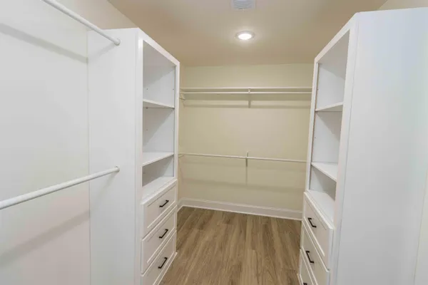 a view of walk in closet with empty racks