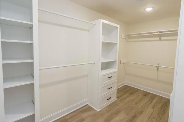a view of walk in closet with empty racks