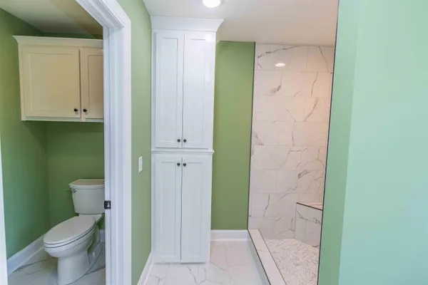 a bathroom with a granite countertop sink a toilet and a shower