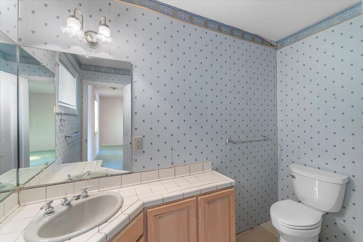 40101 Tassajara Road Carmel Valley, CA 93924 - Photo 40 of 91 a bathroom with a granite countertop sink a toilet and a mirror