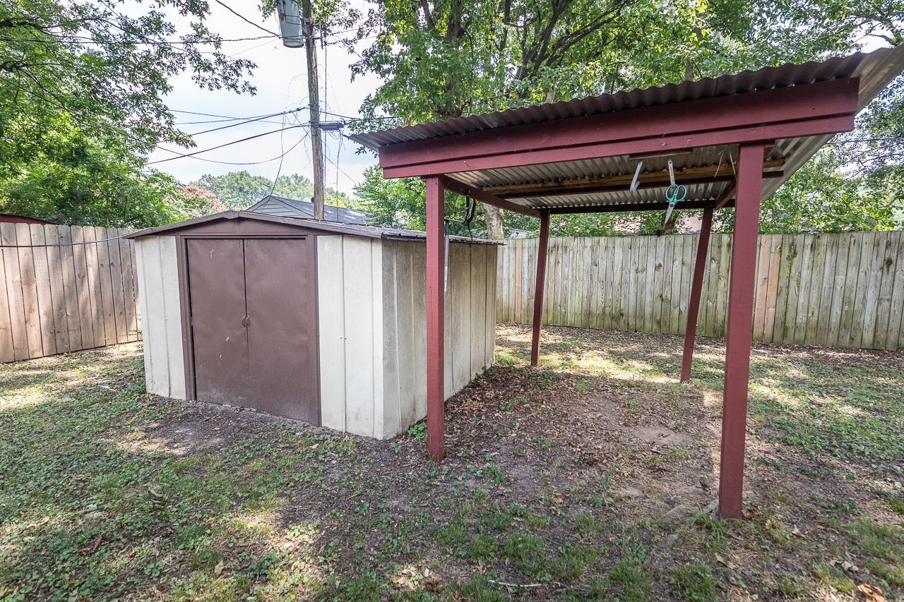 1604 Wilbec Road Memphis, TN 38117 - Photo 21 of 30 a backyard of a house with a large tree and wooden fence