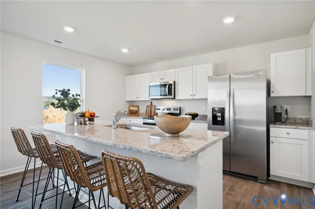 a kitchen with a refrigerator and a view of living room