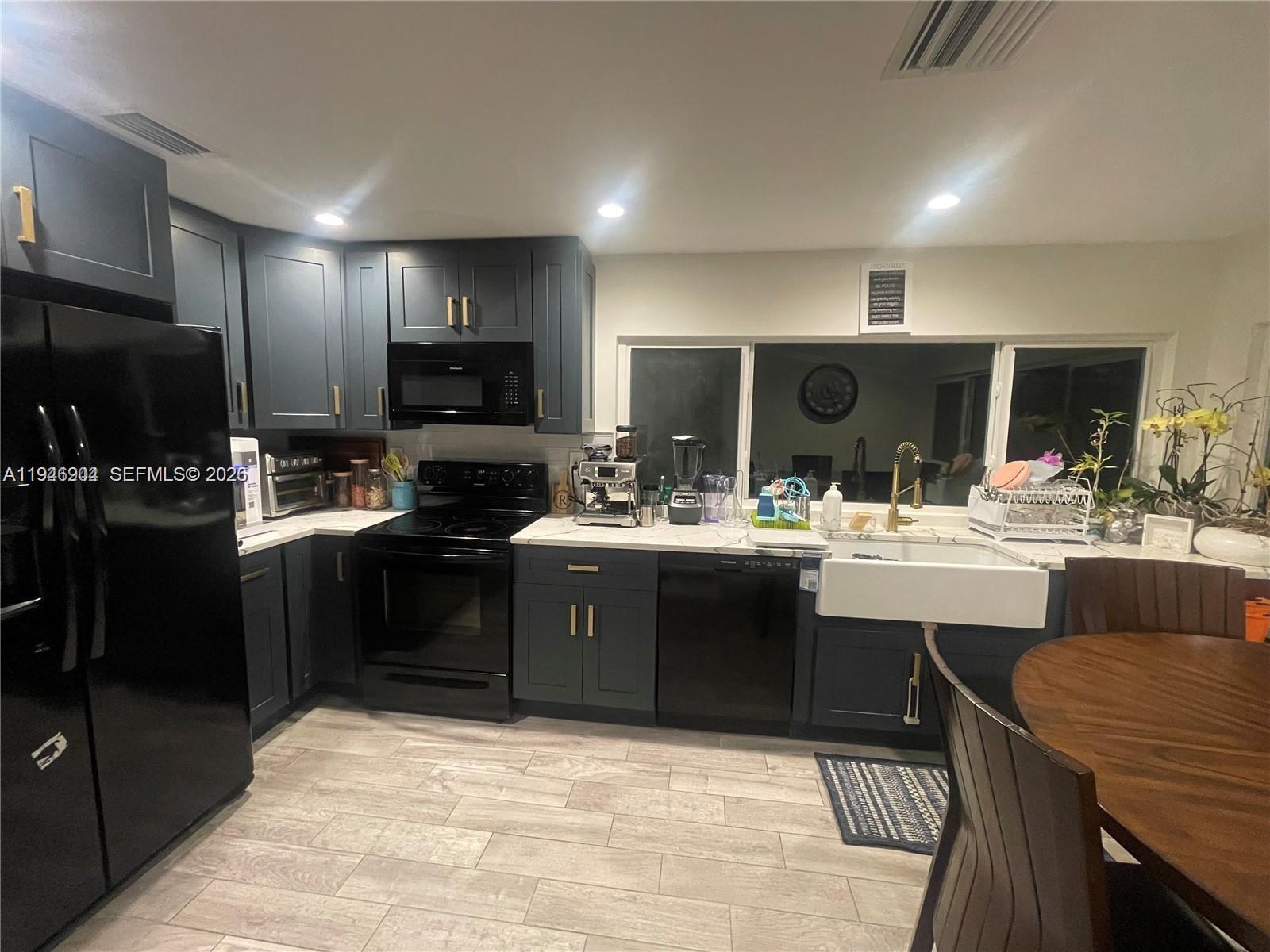 2730 Adams Street Hollywood, FL 33020 - Photo 2 of 8 a kitchen with stainless steel appliances kitchen island granite countertop a sink and cabinets