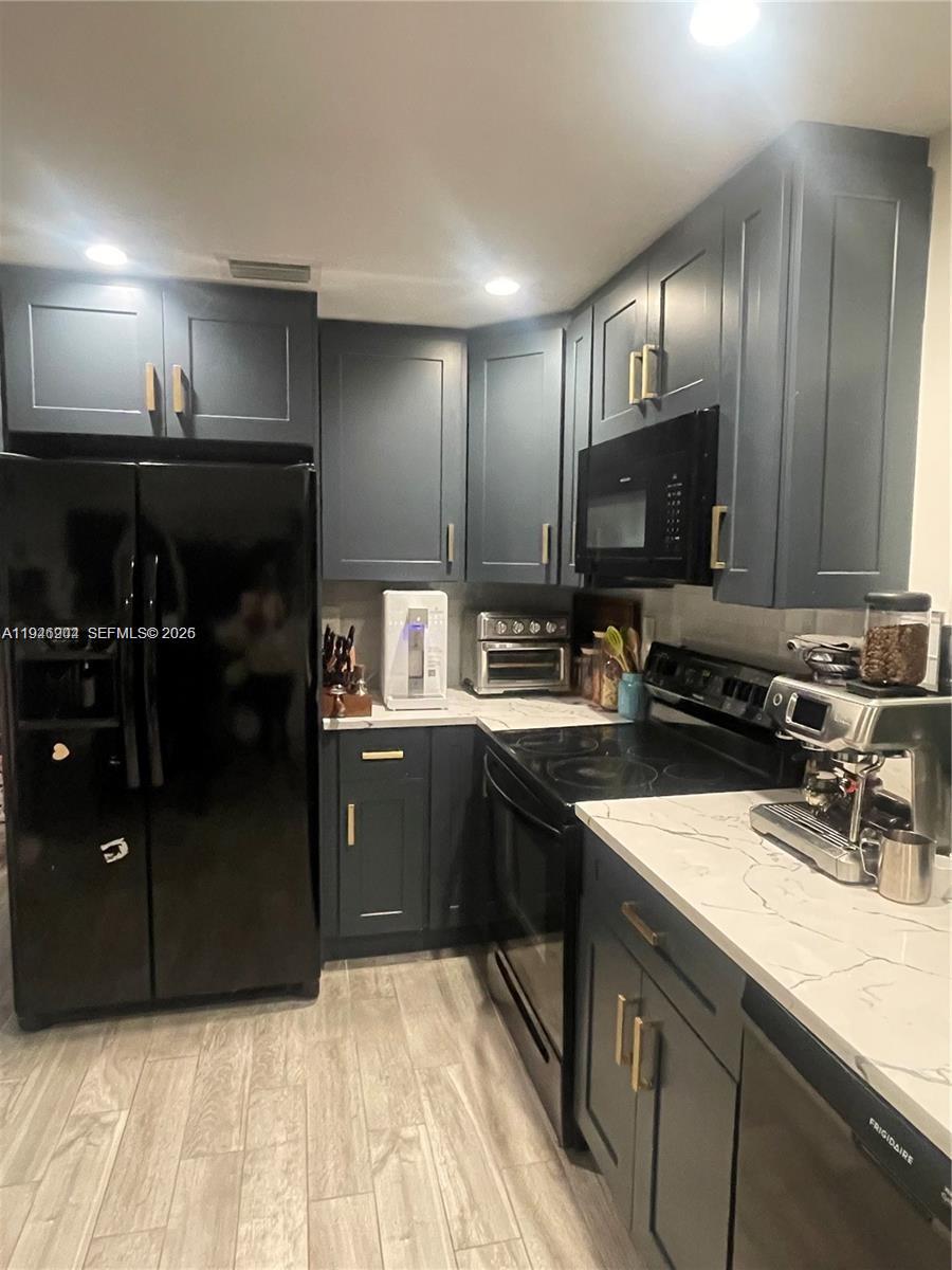 2730 Adams Street Hollywood, FL 33020 - Photo 3 of 8 a kitchen with stainless steel appliances granite countertop a refrigerator and a sink