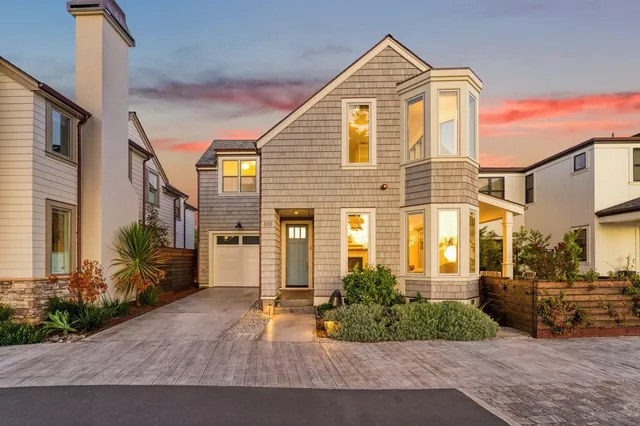 a view of a brick house with many windows and plants