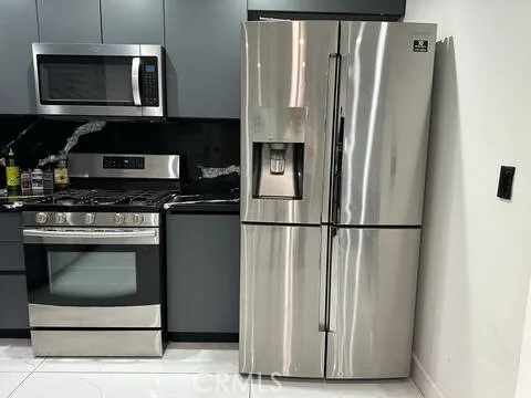 a kitchen with stainless steel appliances a refrigerator a stove a microwave and cabinets