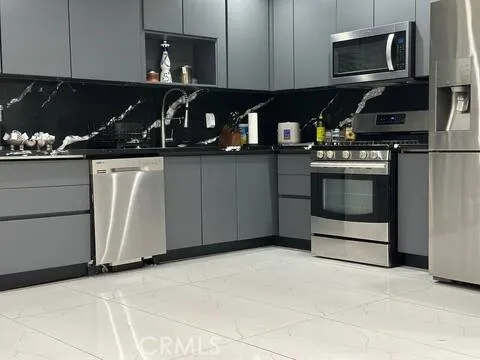 a kitchen with stainless steel appliances granite countertop a stove and a microwave