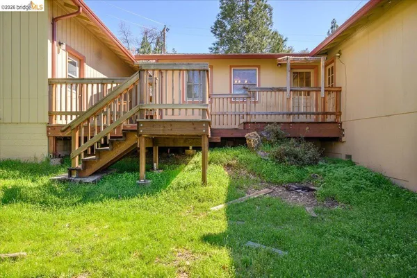 a view of a house with a small yard and deck