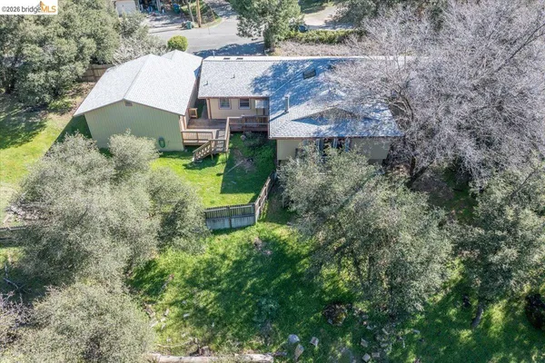 an aerial view of a house with a yard and large trees