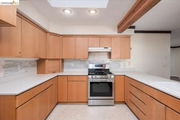 a kitchen with stainless steel appliances granite countertop a sink stove and cabinets