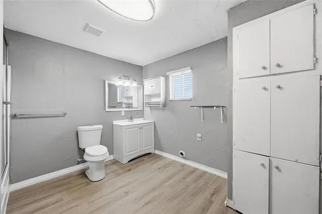 a bathroom with a sink a toilet a mirror and vanity