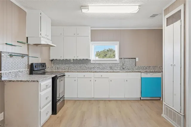a kitchen with stainless steel appliances granite countertop a sink stove and cabinets