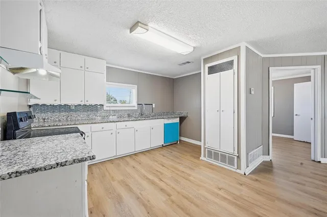 a kitchen with stainless steel appliances granite countertop a sink cabinets and wooden floor