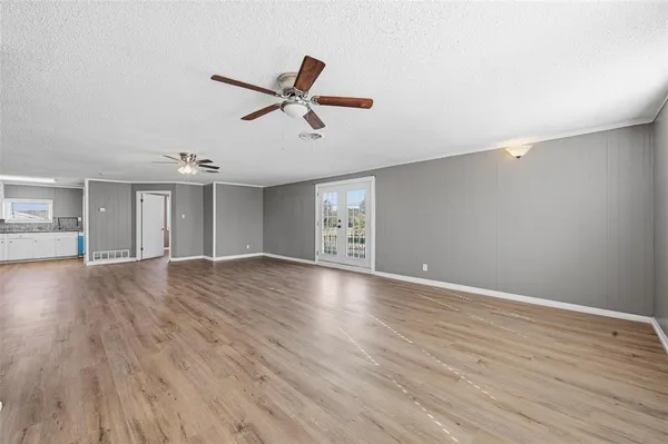 a view of empty room with wooden floor and window