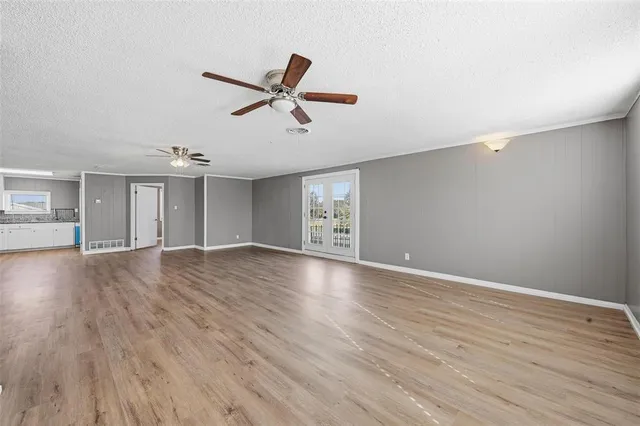a view of empty room with wooden floor and window