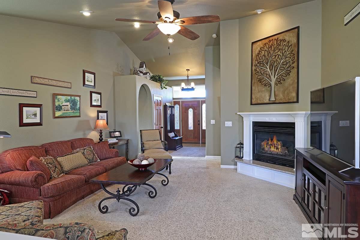 55 Water Lily Court Reno, NV 89511 - Photo 5 of 25 a living room with furniture a chandelier and a fireplace