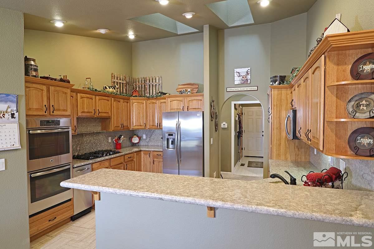 55 Water Lily Court Reno, NV 89511 - Photo 8 of 25 a kitchen with stainless steel appliances granite countertop a refrigerator and a sink