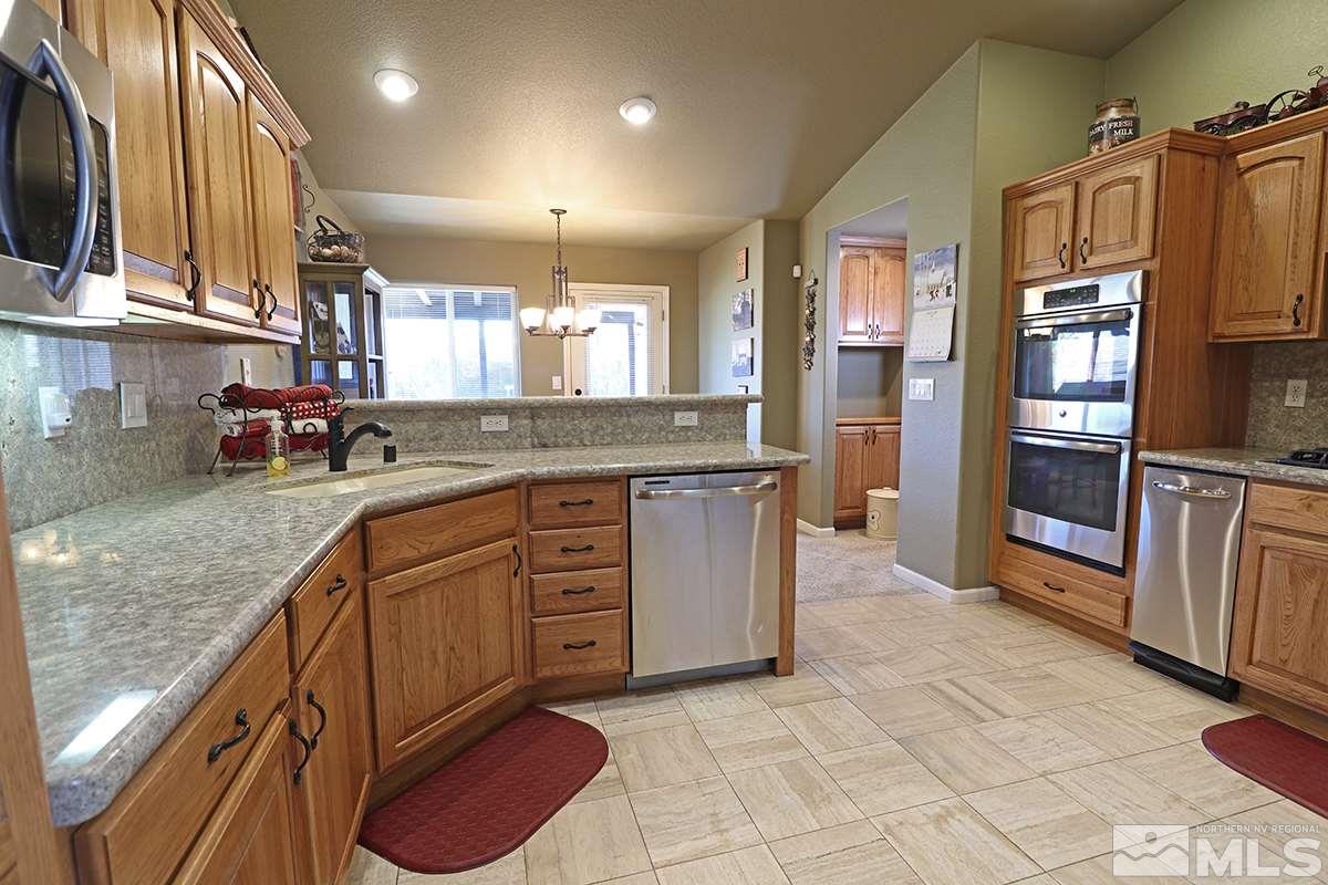 55 Water Lily Court Reno, NV 89511 - Photo 9 of 25 a kitchen with stainless steel appliances granite countertop a refrigerator and a sink
