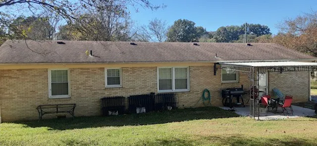 a view of a house with a yard chairs and floor to ceiling window