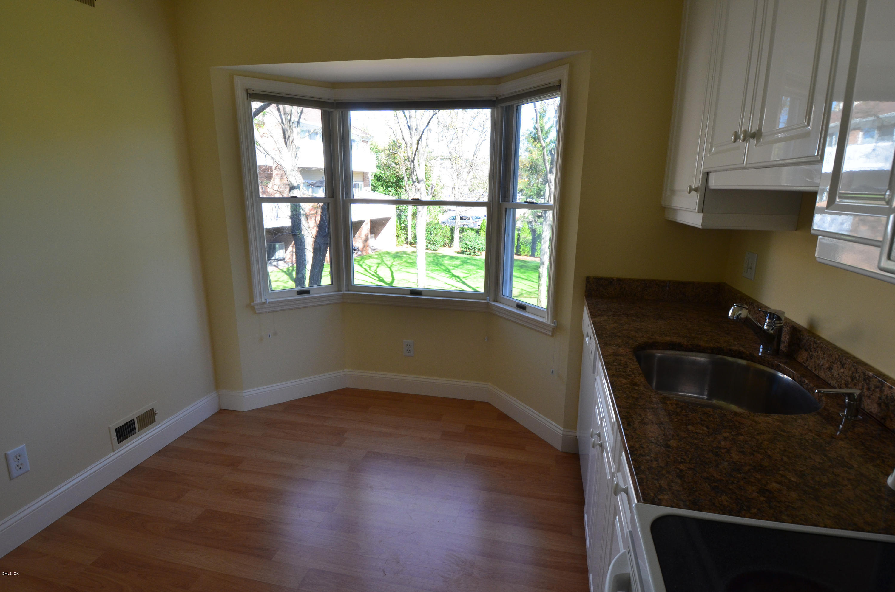 115 River Road, Unit 10 Cos Cob, CT 06807 - Photo 8 of 19 an empty room with wooden floor and a window