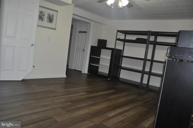 a view of a hallway with wooden floor and stairs