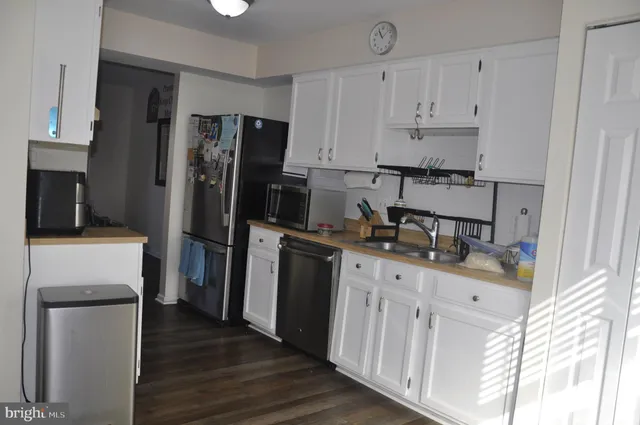 a kitchen with white cabinets and stainless steel appliances