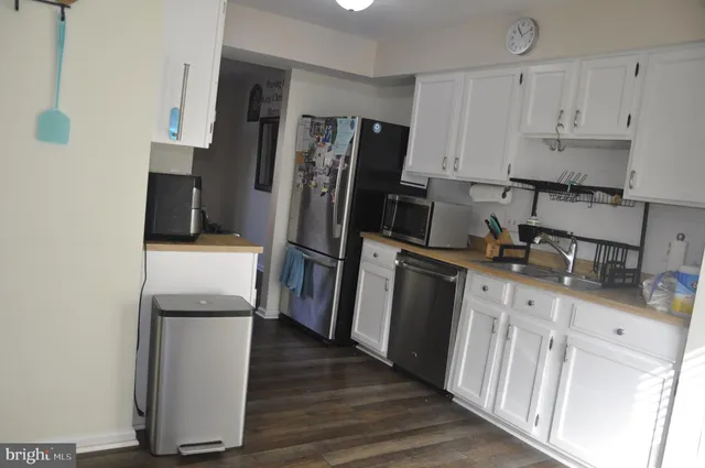 a kitchen with a refrigerator sink and cabinets