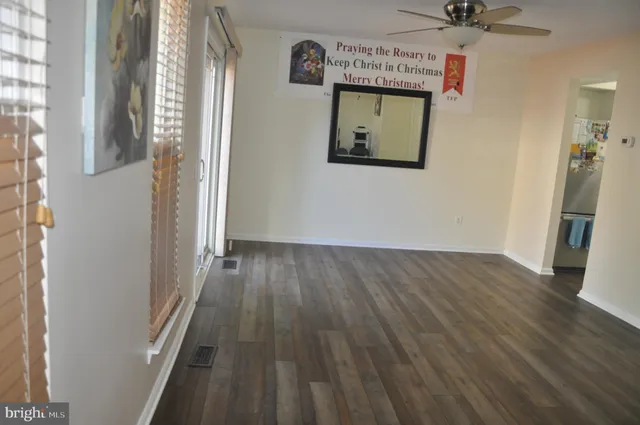 a view of a hallway with wooden floor and a cabinet