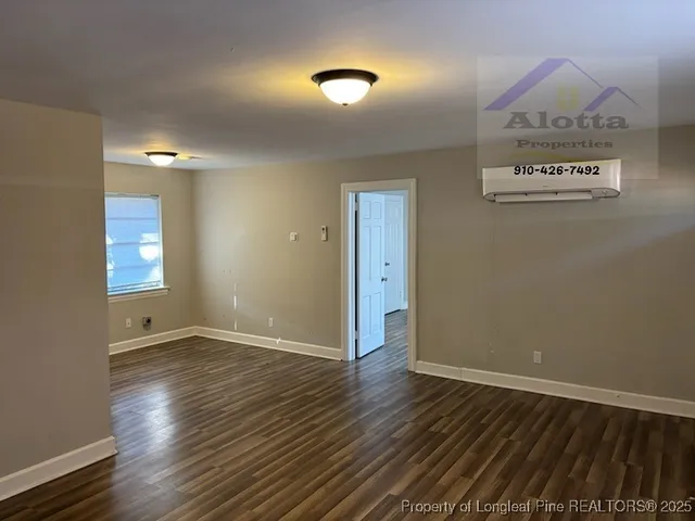 an empty room with wooden floor and mirror
