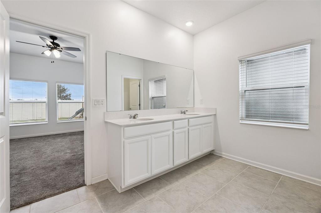 781 Taurus Lane St. Cloud, FL 34772 - Photo 22 of 36 a spacious bathroom with a double vanity sink and mirror