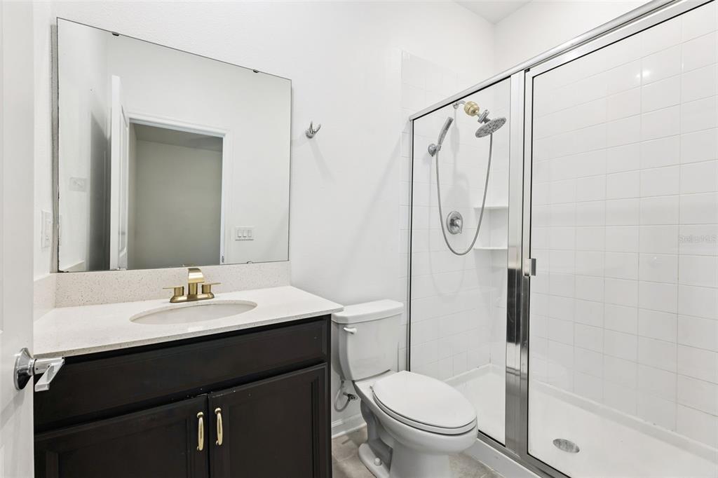 781 Taurus Lane St. Cloud, FL 34772 - Photo 24 of 36 a bathroom with a granite countertop sink toilet and shower
