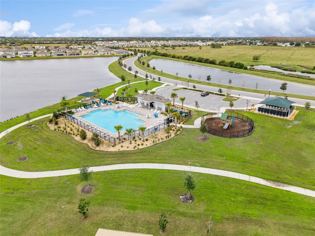 781 Taurus Lane St. Cloud, FL 34772 - Photo 35 of 36 a view of a swimming pool with a table and chairs next to a yard