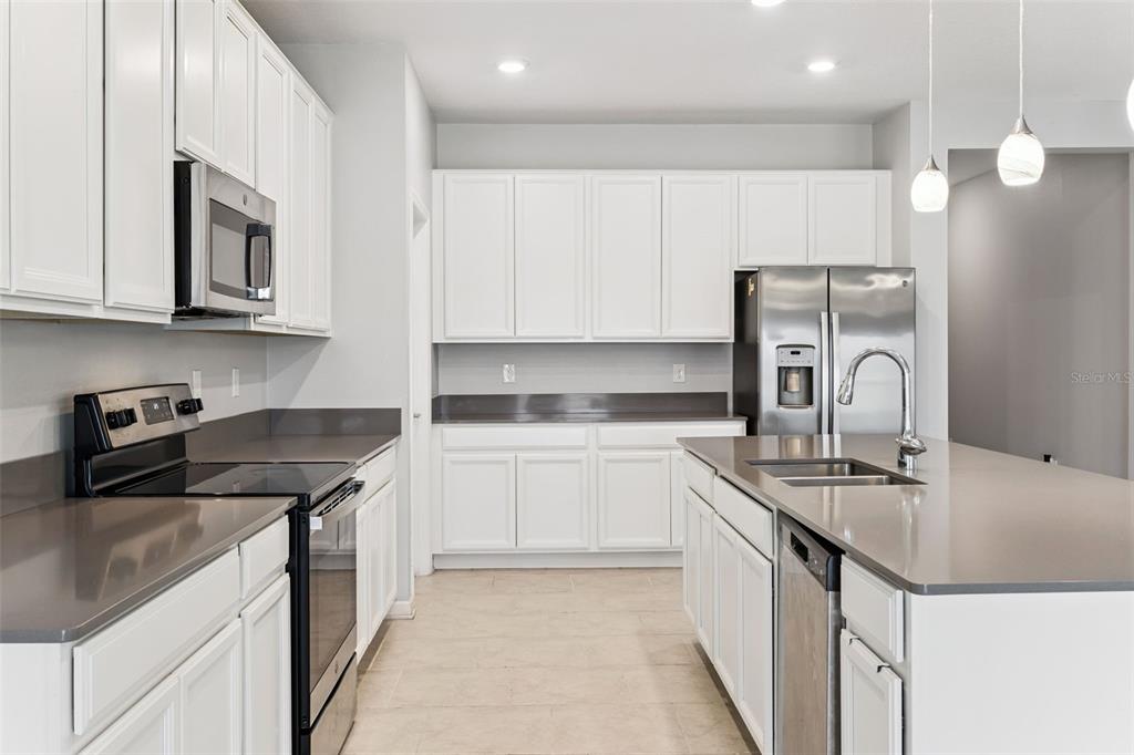 781 Taurus Lane St. Cloud, FL 34772 - Photo 10 of 36 a kitchen with stainless steel appliances granite countertop a sink stove and cabinets