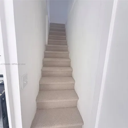 a view of staircase with white walls