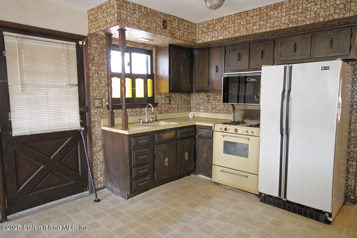3 Windermere Road Staten Island, NY 10305 - Photo 23 of 37 a kitchen with a white stove top oven and refrigerator