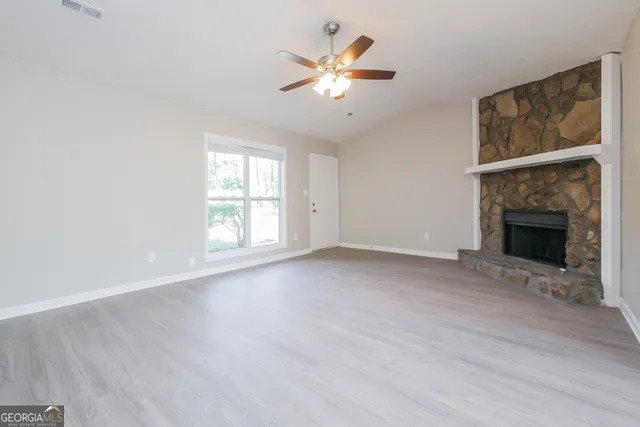 an empty room with windows a fireplace