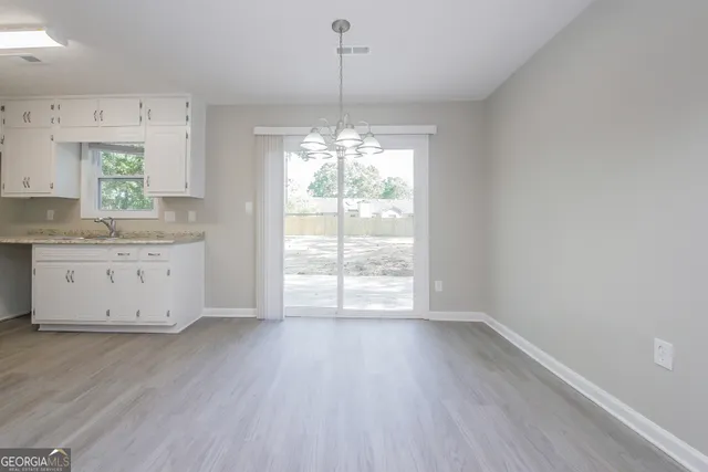 a view of a kitchen with wooden floor and a window