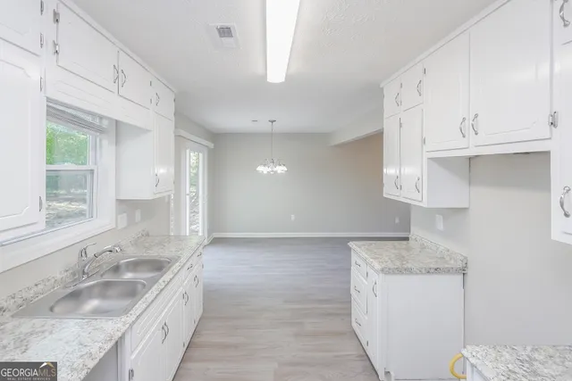 a bathroom with granite countertop a sink a toilet and vanity