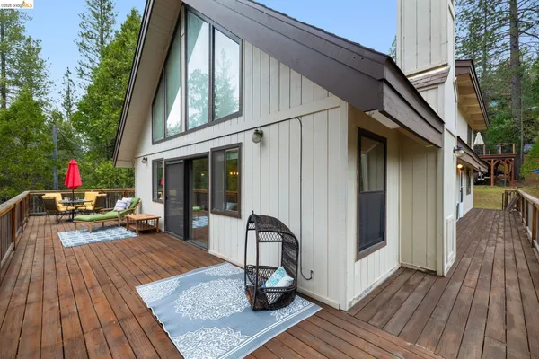 a view of a two chairs and table on the wooden deck