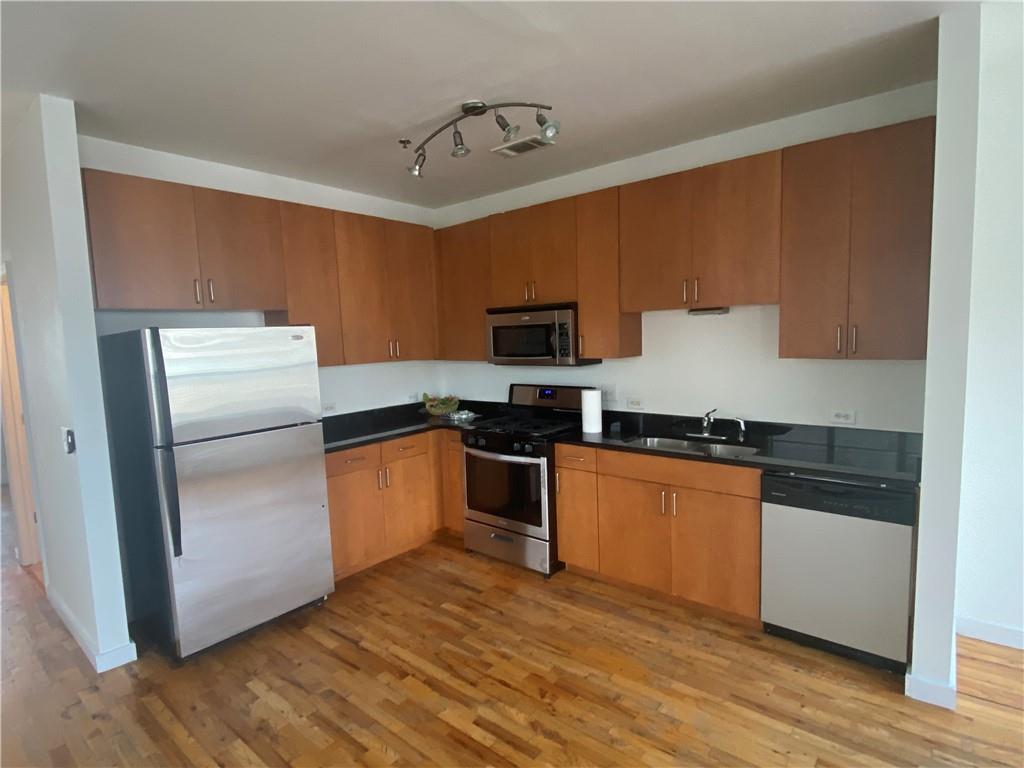 238 Walker Street Southwest, Unit 27 Atlanta, GA 30313 - Photo 1 of 1 a kitchen with granite countertop a refrigerator stove top oven and sink
